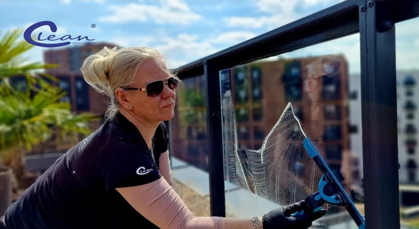 Mycie szklanej balustrady przez pracownika Clean Service Pro